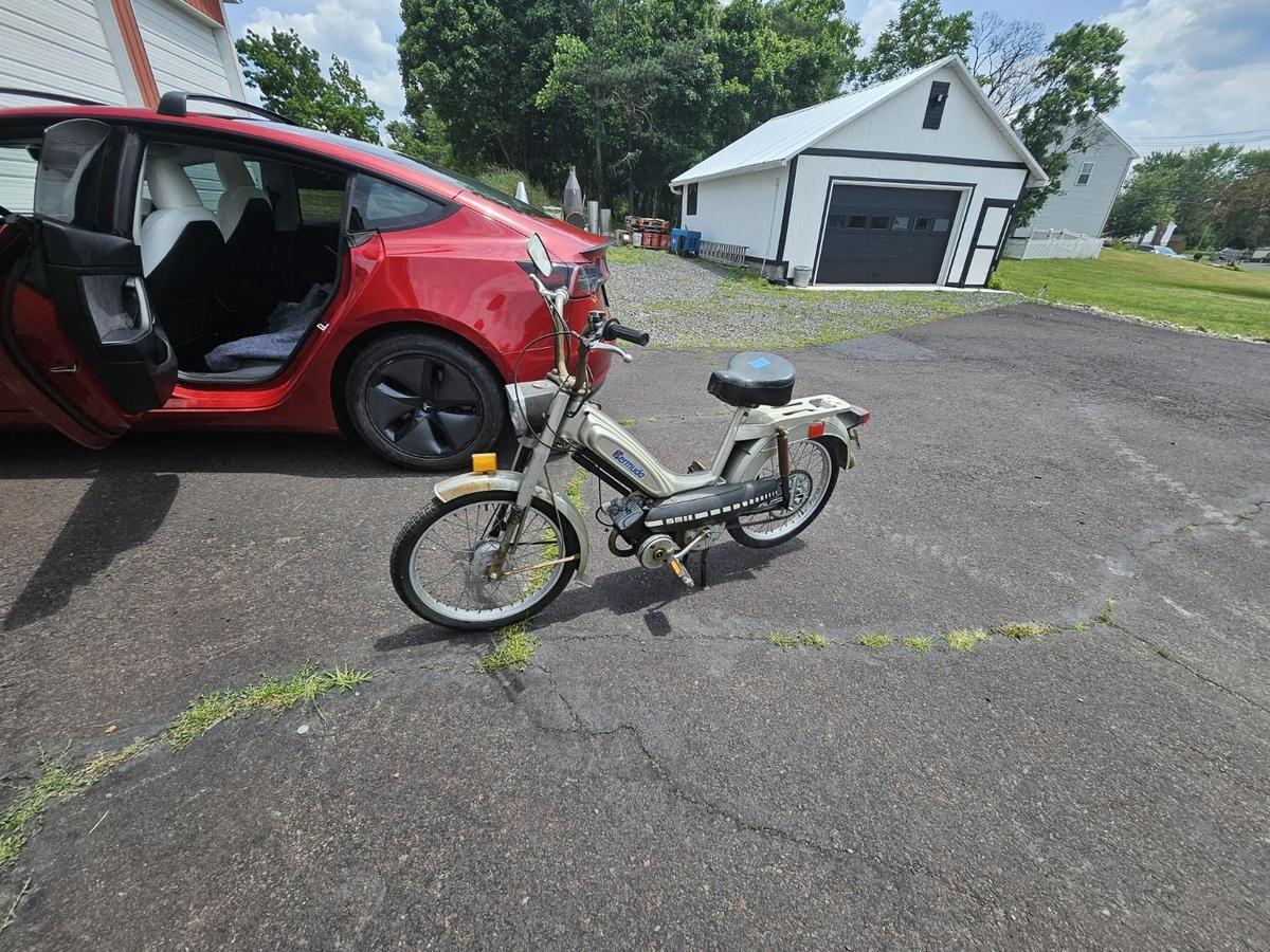 Moped next to Tesla at home